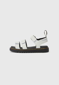 Witte leren sandalen met drie verstelbare banden, een zwarte gestructureerde zool en oranje stiksels langs de basis, met een trekhaak.