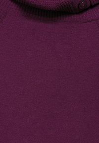 Maglione a collo alto in un profondo viola, caratterizzato da un tessuto testurizzato e un singolo bottone al collo per la chiusura. Design morbido e aderente.