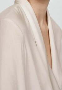 Beige zavinovací blůza s hlubokým výstřihem do V, hladkým povrchem a měkkým splýváním. Má šálový límec pro pohodlný střih.