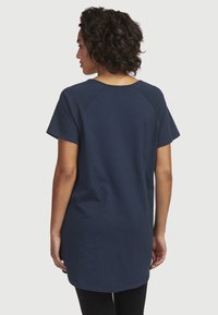 Dunkelblaues Baumwoll-T-Shirt mit kurzen Ärmeln, Rundhalsausschnitt und verlängertem Rückensaum. Glatte Textur mit Raglan-Ärmeldesign.