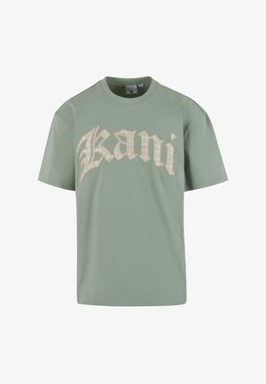 T-shirt in cotone verde menta con vestibilità over size, caratterizzata da un grande testo decorativo color crema "Kani" sulla parte anteriore. Maniche corte, scollatura rotonda.