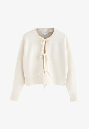 Cardigan tricotat de culoare crem, cu mâneci lungi, manșete și tiv cu dungi, decolteu rotund și trei închideri cu funda în față.