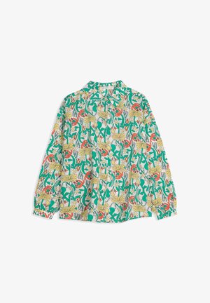 Camisa de manga larga con botones y un patrón colorido de flores y hojas en verde, amarillo y rojo sobre un fondo blanco.