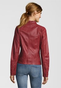 Rote Lederjacke mit einer taillierten Passform, glatter Textur und genähten Details. Verfügt über Reißverschlussmanschetten und einen hohen Kragen.