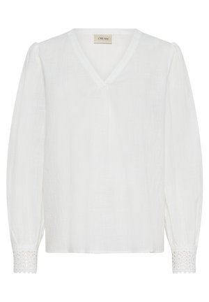 Balta garām piedurknēm blūze ar V veida izgriezumu, teksturētu audumu un mežģīnēm piedurkņu galiņos. Brīvs siluets ar sasietām pleciem.