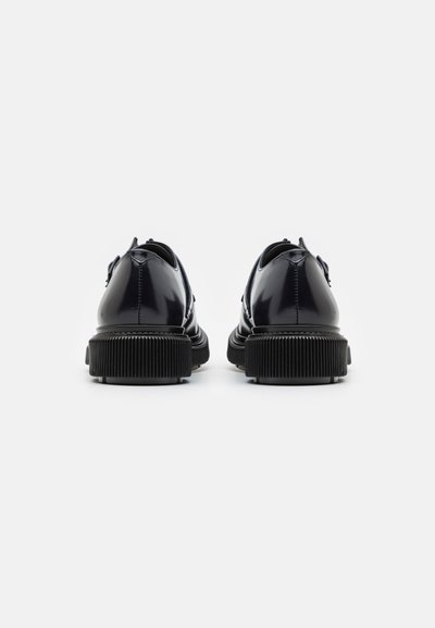Pantofi din piele lacuită bleumarin cu vârful rotund, talpă texturată din cauciuc negru și două găuri pentru șireturi. Design minimalist cu o finisare netedă.