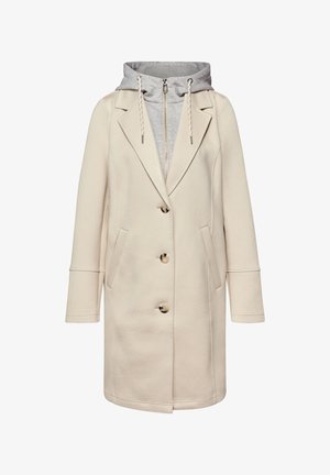 Manteau beige longueur genou avec col à revers, trois boutons, et sweat à capuche gris attaché en dessous avec cordons de serrage et fermeture éclair.
