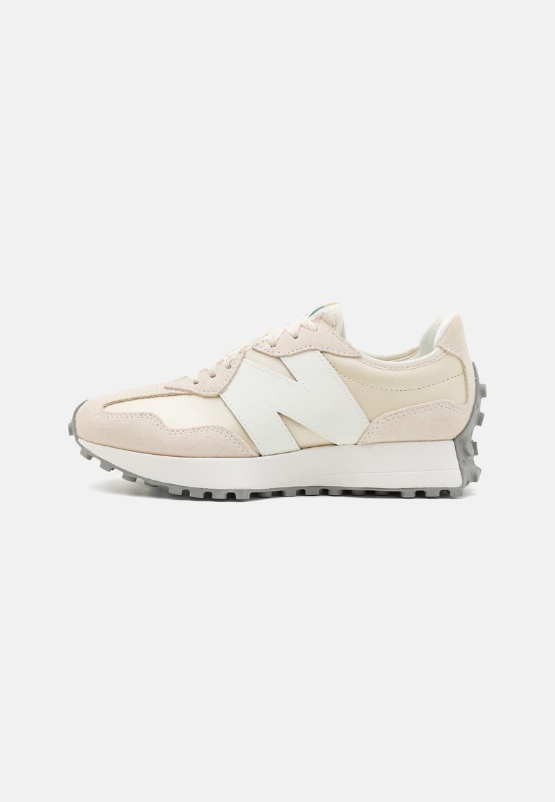 Baskets New Balance beige et blanc cassé avec logo blanc "N", design à lacets et semelle grise texturée vue de profil.