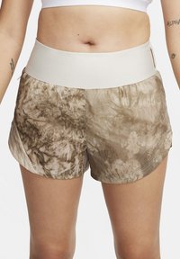 Brune og beige mønstrede treningsshorts med en bred, lysfarget midjebånd og sideslisser i kanten for økt bevegelighet.