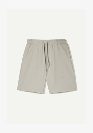 Svetle šedé sportovní šortky vyrobené z hladké, prodyšné látky. Mají elastický pas se šňůrkou a jemné boční švy.