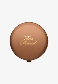 Ronde compact met een glad, koperkleurig oppervlak waarop "Too Faced" in goud is weergegeven. Gouden rand langs de rand.