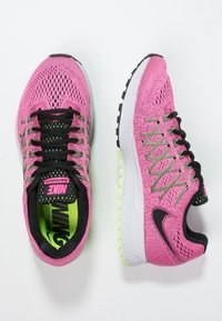Un paio di scarpe da corsa Nike Zoom Pegasus 32 rosa con lacci neri e dettagli verdi su sfondo bianco.