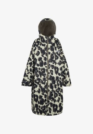 Kobieta ubrana w czarno-biały płaszcz w print lamparta o długości do połowy uda, niebieskie dżinsy, beżowe pantofle wsuwane i czarną torebkę na ramię, stojąca na jednolitym tle.