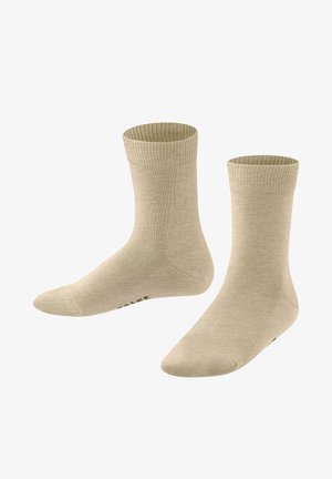 Beige sokken gemaakt van gladde stof, met een geribbeld boord en versterkte teen. Eenvoudig ontwerp zonder patronen of extra accenten.
