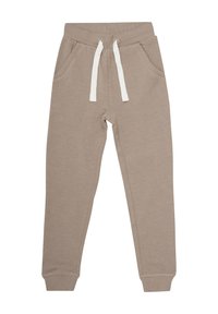 Pantalons de survêtement beiges en tissu doux, avec des poches latérales et un cordon blanc à la ceinture élastique. Ajustés au niveau des poignets.