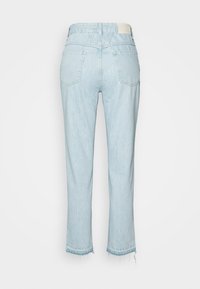 Světle modré džíny z denimu s vysokým pasem, pětic pocket designem, roztrženým lemem a mírným opotřebením na spodní části. Zadní strana obsahuje poutko na pásek a značka štítek.