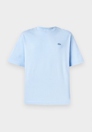 T-shirt in cotone blu chiaro con colletto rotondo, maniche corte e un piccolo logo ricamato sulla parte sinistra del petto. Tessuto morbido, vestibilità rilassata.