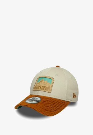 Cap with a tan fabric top and an orange fuzzy visor. Features a mountain graphic patch and a textured front panel. New Era logo on side.