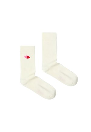 Paire de chaussettes blanches montantes, une chaussette présente un petit motif de cœur rouge et rose sur le côté extérieur près du haut.