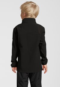 Svart mjukskalet jacka med lång ärm, hög krage och elastiska manschetter, med en stilren design utan synliga knappar eller mönster.
