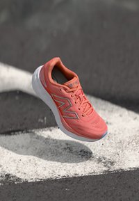 Sportschuh mit einem leichten, atmungsaktiven Korallennetz-Obermaterial, weißer Sohle und reflektierenden silbernen Akzenten. Verfügt über ein strukturiertes Design und Schnürung.