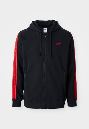 Hoodie noir zippé Nike avec des accents rouges sur les manches, des poches kangourou et un logo brodé en rouge sur la poitrine.