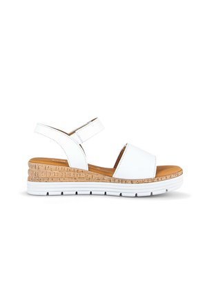 White wedge sandal with cork midsole, adjustable ankle strap, and white rubber outsole, shown in side profile on white background.