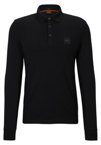Svart långärmad slim-fit polotröja med tre knappar och en liten BOSS-logotyp på vänster bröst.