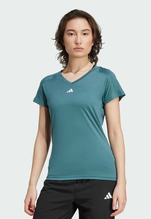 T-shirt de sport teal avec manches courtes, col en V, fabriqué en tissu lisse et respirant ; présente un logo de marque discret sur la poitrine.