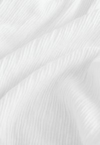Tissu blanc texturé avec des motifs en ondulations, fabriqué à partir d'un matériau léger, mettant en avant la douceur et un éclat subtil.
