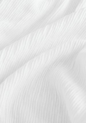 Valge tekstuuriga kangas lainelaadsete mustritega, valmistatud kerge materjali, kujutades pehmust ja õrna läiget.