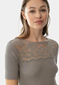 Light gray ribbed t-shirt featuring a floral lace overlay at the neckline and shoulders. Short sleeves with a fitted design.