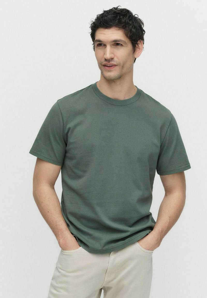 Grön bomullströja med rund halsringning, korta ärmar och en klassisk passform. Texturerat tyg med minimala sömdetaljer.