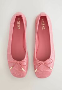 Roosad baleriinakujulised madalad kingad krokodilinäolise tekstuuriga, ümmarguse varbaosaga ja ees lipsudetailiga. Kuldse viimistlusega metallosad ja pehme sisevooder.