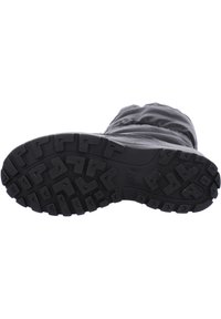 Suela de bota de nieve negra con un patrón de banda de rodadura profundo, hecha de goma para proporcionar tracción. Presenta una parte superior flexible con textura fruncida para mayor calidez.