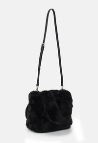 Černá crossbody kabelka z umělé kožešiny s texturovaným povrchem, nastavitelným černým popruhem a zlatými kovovými detaily. Čtvercový tvar s měkkými okraji.