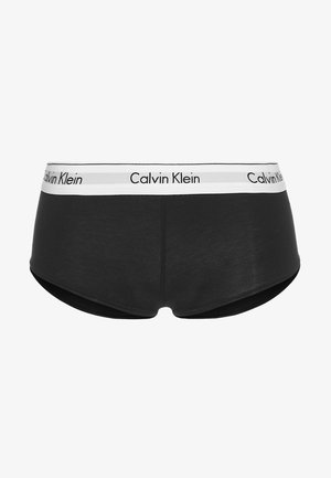 Zwarte katoenen boxershorts met een witte merkband met het "Calvin Klein" logo in zwarte tekst. Gladde structuur, middelhoge pasvorm.
