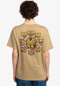 Beige t-shirt featuring a colorful bear graphic design on the back, with various bear faces and a central bear holding a stick.