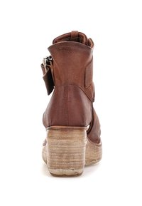 Brune læder ankelstøvle med stabelhæls af træ og sidezipper set fra ryggen på en hvid baggrund.