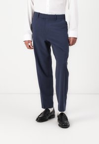 Pantalones de corte en azul marino, confeccionados con una tela suave y ligera. Cuentan con una parte delantera plana, presillas para cinturón y un diseño de pierna recta.
