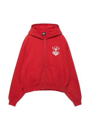 Červená mikina na zips s prednými vreckami, kapucňou a bielym emblémom na ľavej strane hrudníka s nápisom "STWD 1991" a obrázkom vtáka.