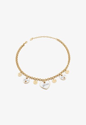 Gouden ketting met meerdere charms, waaronder twee emaille harten en ronde tags die zijn gegraveerd met "Guess" en logo's.
