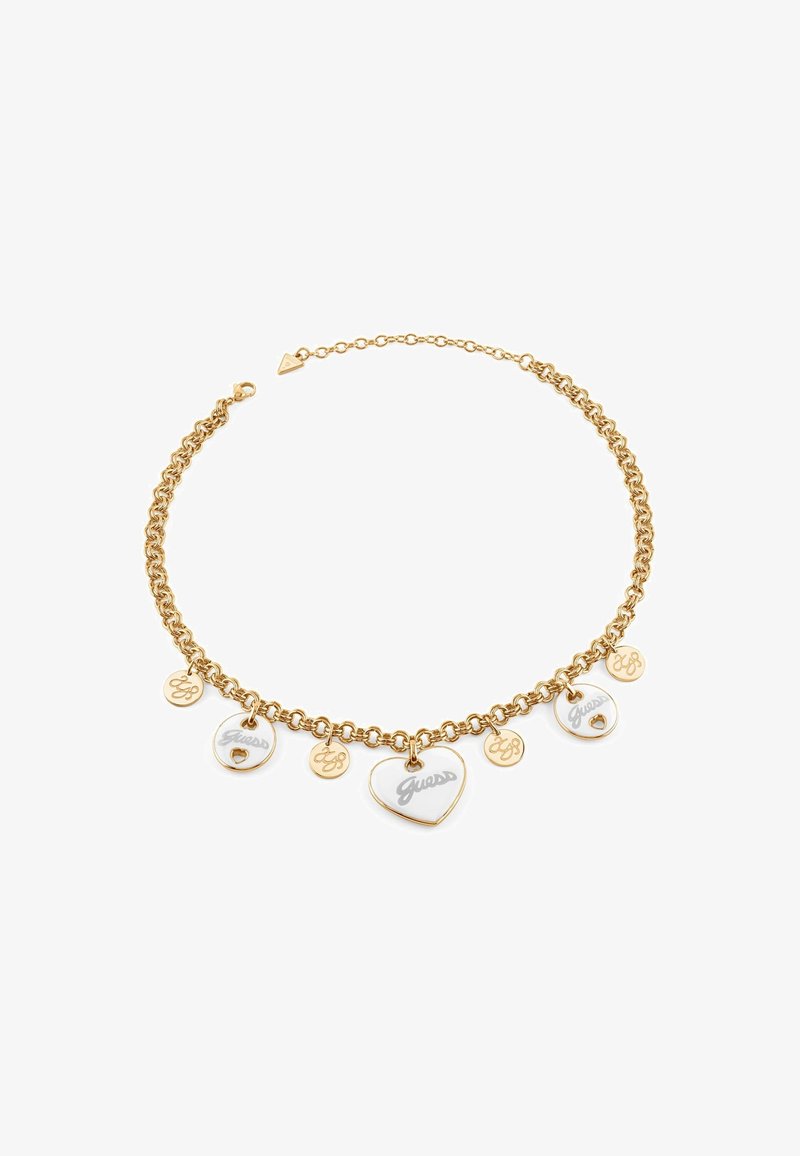 Gold-tone chain necklace featuring multiple charms, including two enamel hearts and circular tags engraved with "Guess" and logos.