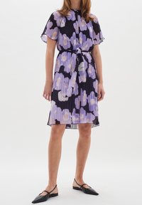 Kukkaprintti mekko mustassa, purppurassa ja vaaleanpunaisessa. Sisältää pleatattu muotoilu, lyhyet hihat ja sidottavan vyön. Siisti kangas.