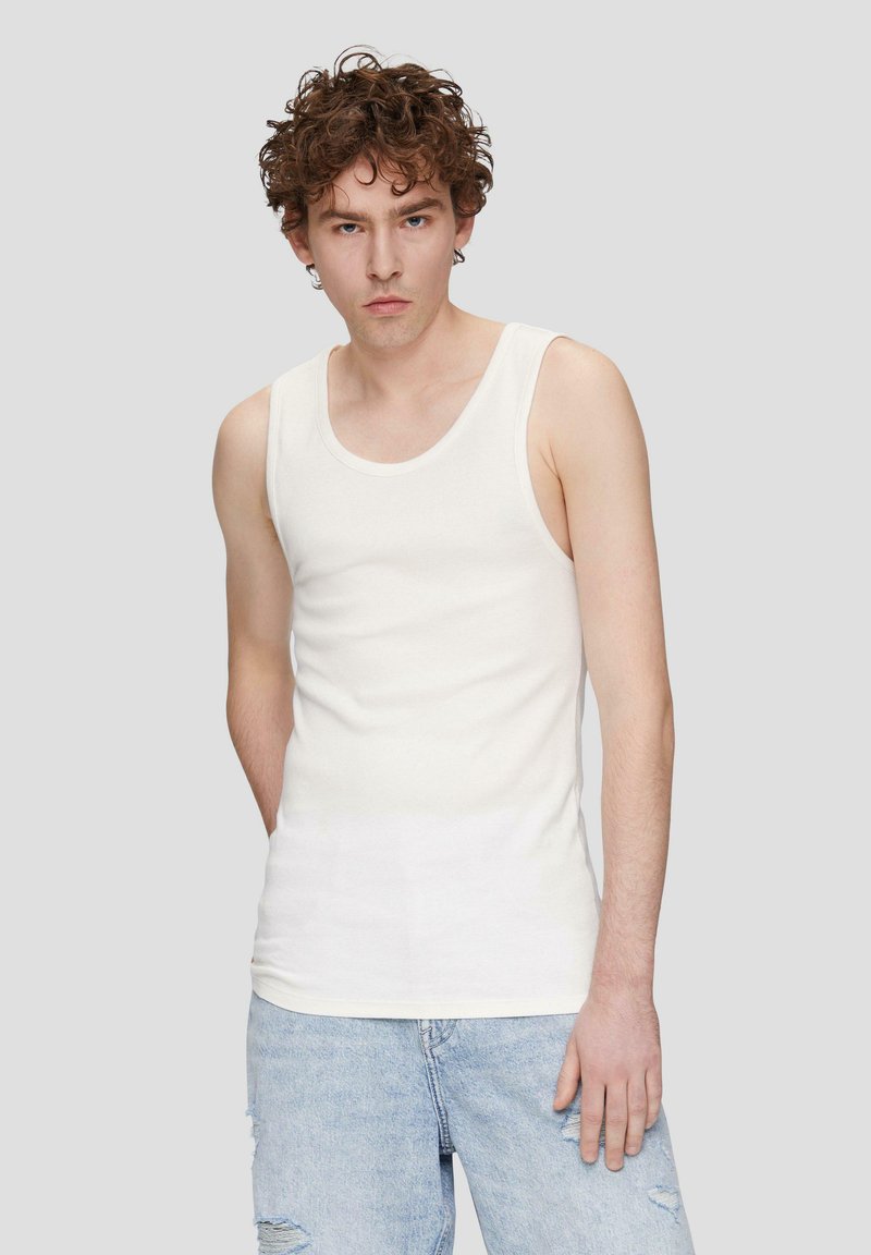 Witte mouwloze tanktop van een zachte katoenmix, met een ronde halslijn en een aansluitende pasvorm, gecombineerd met lichtblauwe verbroken jeans.