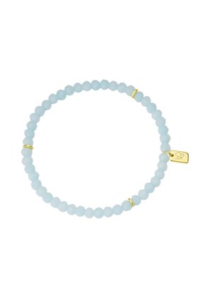 Bracelet élastique avec des perles rondes bleu clair et de petits anneaux dorés, accompagné d'un charm en or avec un symbole de colombe gravé.