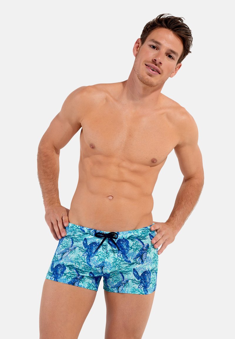 Blaue Badeshorts mit einem Muster aus Korallen und Meeresschildkröten. Hergestellt aus leichtem Material, mit einem verstellbaren Bund und einem kurzen Design.