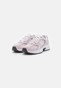 Paar pink-weißer New Balance Laufschuhe mit weißen Schnürsenkeln und schwarzen Gummisohlen auf einem weißen Hintergrund.