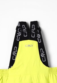 Salopette de ski jaune avec taille élastique et bretelles noires ajustables arborant le logo "CMP" en blanc. Texture lisse et design fonctionnel.