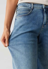Lichtblauwe denim jeans met een recht model, voorzien van zichtbare naden, voorzakken en een middelhoge tailleband.